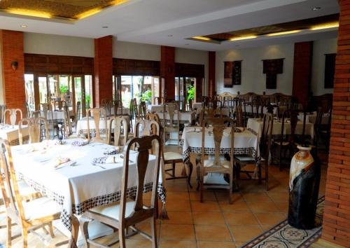 a dining room with white tables and chairs at Omah Sinten Heritage Hotel & Resto in Solo