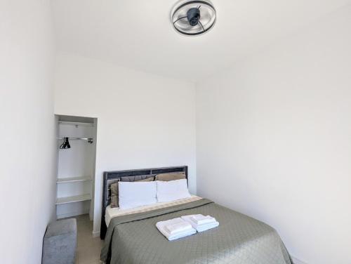 une chambre avec un lit et une horloge au mur dans l'établissement Appartement SEA-Azur panorama Nice Fabron, à Nice