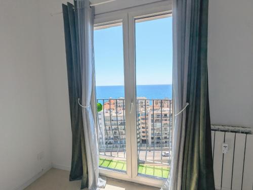 Cette chambre dispose d'une fenêtre offrant une vue sur l'océan. dans l'établissement Appartement SEA-Azur panorama Nice Fabron, à Nice