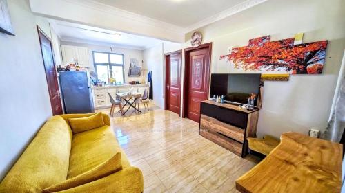 a living room with a couch and a tv and a kitchen at Sun Penthouse in Flic-en-Flac
