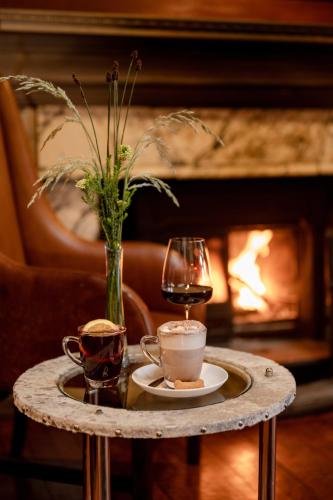 a table with a glass of wine and a vase at Camps Bay Retreat Hotel in Cape Town
