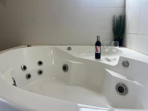 a white bath tub with a bottle of wine and glasses at Genesis Land Desert hospitality in Kfar Adumim