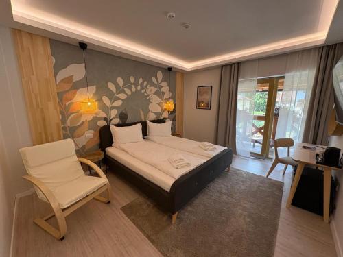 a bedroom with a bed and two chairs in it at Vila Salt & Soul in Sovata