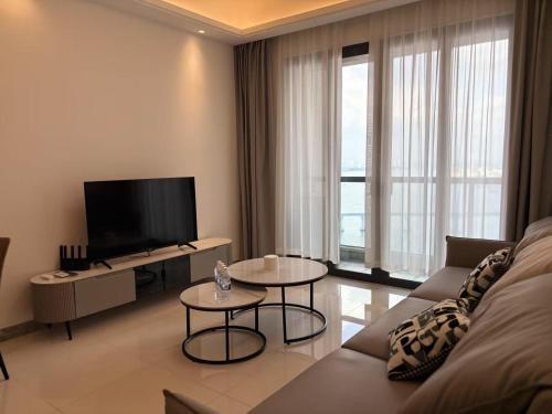 a living room with a couch and a flat screen tv at TheBess Hotel Tokyo is located adjacent to Singapore and offers a sea viewIt is a family business smart room with the sea view of Princess Bay富力公主湾 in Johor Bahru