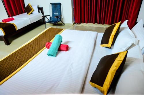 a hotel room with two beds with towels on them at Kumbles Misty Mount in Attigundi