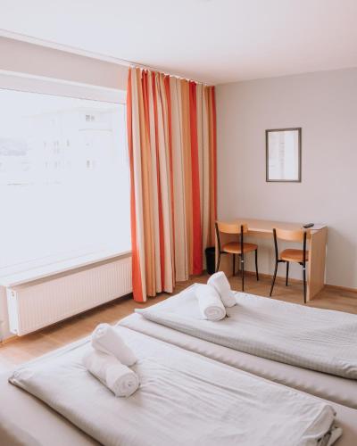 a hotel room with two beds and a table at Campus Bad Kissingen in Bad Kissingen