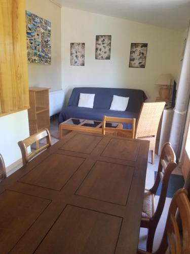 a room with a bed and a table and chairs at appartement familial - Beau jardin in Sauveterre-de-Rouergue