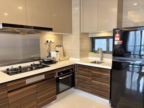a kitchen with a black refrigerator and a sink at TheBess Hotel Tokyo is located adjacent to Singapore and offers a sea viewIt is a family business smart room with the sea view of Princess Bay富力公主湾 in Johor Bahru