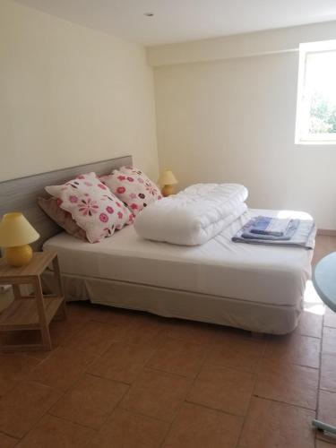a bedroom with a bed with two pillows on it at appartement familial - Beau jardin in Sauveterre-de-Rouergue