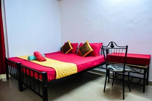 a bed with colorful pillows on it with a chair at Kumbles Misty Mount in Attigundi
