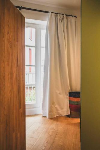 an open door with a curtain and a window at Appartements Brigg & Schoner in Neuharlingersiel