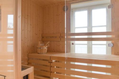 a sauna with a window and wooden walls at Appartements Brigg & Schoner in Neuharlingersiel