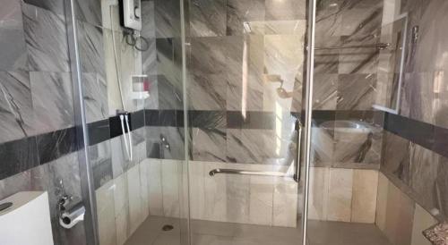 a bathroom with a shower with a glass door at Rest@Ratchada hotel in Bangkok
