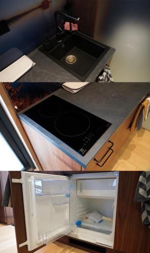 a kitchen counter with a sink and an open refrigerator at Peegelmaja in Otepää