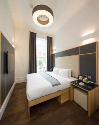 a hotel room with a large bed and a window at The Z Hotel Gloucester Place in London