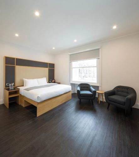 a hotel room with a bed and two chairs at The Z Hotel Gloucester Place in London