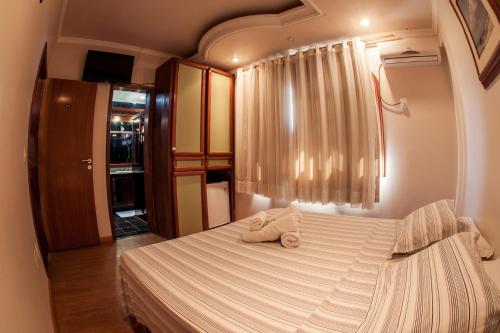 1 dormitorio con 1 cama con 2 toallas en Pousada Baía dos Corais, en Penha