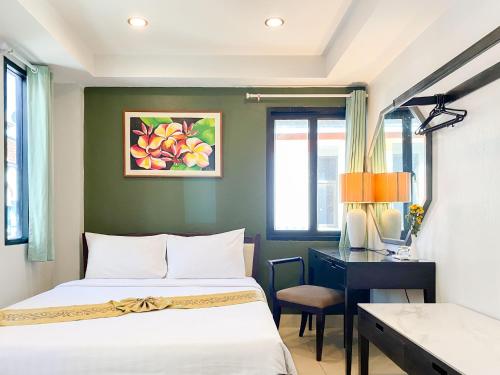 a bedroom with a bed and a desk with a desk at The Corner in Patong Beach