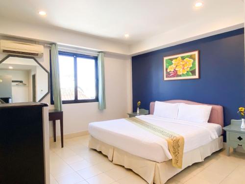 a bedroom with a large bed with a blue wall at The Corner in Patong Beach
