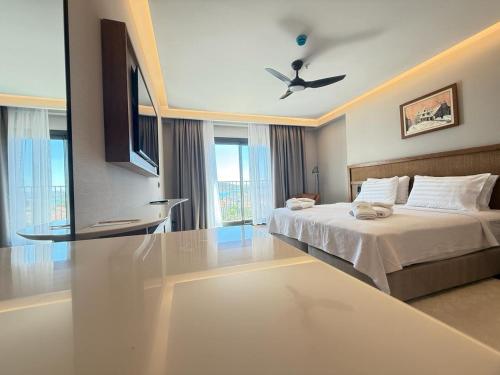 a bedroom with a bed and a ceiling fan at Cunda Kızılca Deluxe Hotel & SPA in Ayvalık