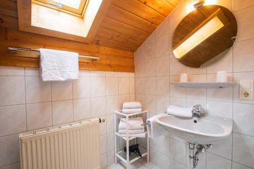 une salle de bain blanche avec un lavabo et une fenêtre dans l'établissement Aschenauer Hof, à Ruhpolding