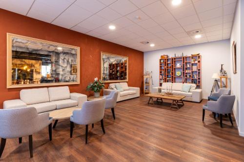 a waiting room with couches and a table and chairs at Antwerp Harbour Hotel in Antwerp