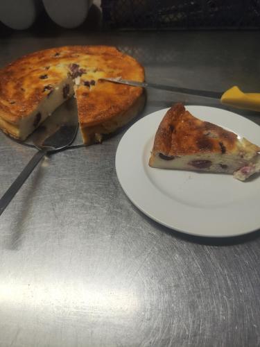 a slice of pizza on a plate on a table at l'Adapté in Raon-lʼÉtape