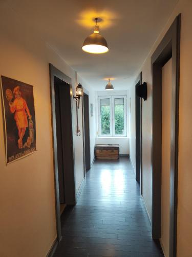 a hallway of a house with a painting on the wall at l'Adapté in Raon-lʼÉtape