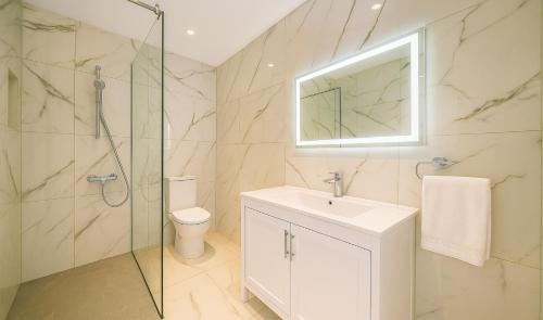 ein Badezimmer mit Toilette, Waschbecken und Dusche in der Unterkunft HiddenGems Residences 202 - The LXR Penthouse - Pool & Beach Steps in Paphos City