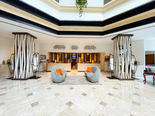 a living room with two chairs and a table at Grand Diamond Hotel Yogyakarta - Formerly Grand Quallity Hotel in Yogyakarta