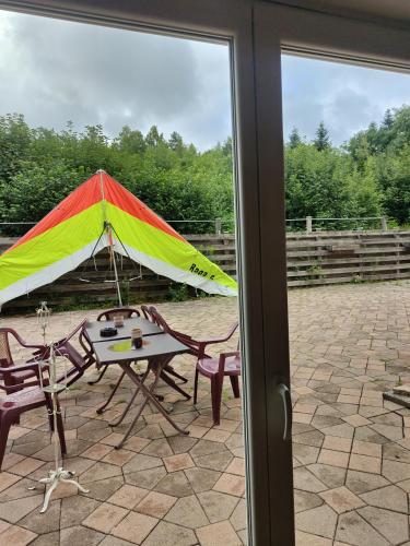 a kite sitting on a patio with a table at l'Adapté in Raon-lʼÉtape