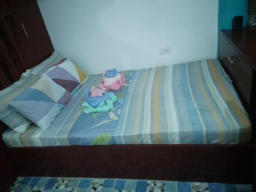 two stuffed animals sitting on top of a bed at Casa De Moore - Ocean & Garden View Siargao in General Luna