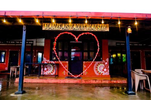 a red heart sign in front of a restaurant at Kumbles Misty Mount in Attigundi