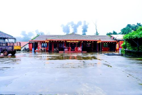 an empty parking lot in front of a building at Kumbles Misty Mount in Attigundi
