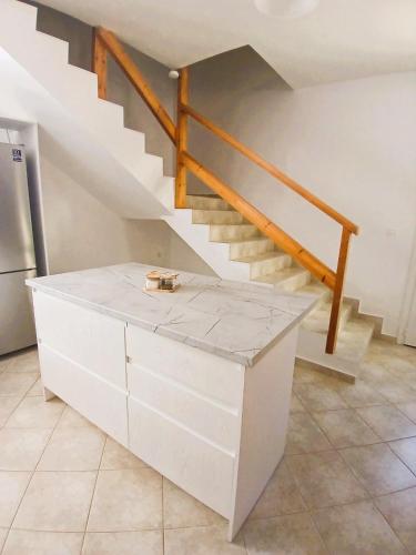a white cabinet in a kitchen with a staircase at Sti Physi in Keramiaí