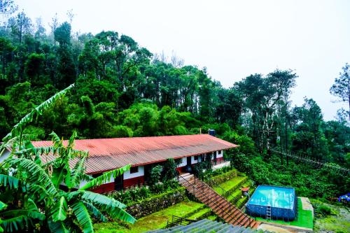 a small house in the middle of a forest at Kumbles Misty Mount in Attigundi