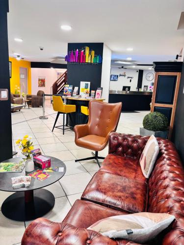 a leather couch and a table in a store at Hotel Le Gambetta in Bergerac