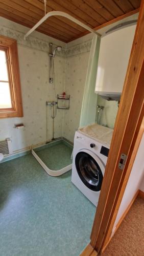 a washing machine in a room with a shower at Säbytorp in Kil