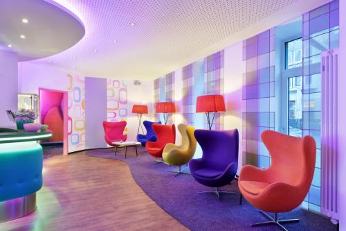 a waiting room with colorful chairs and tables at Cityhotel Thüringer Hof Design Hannover - Self Check-In in Hannover