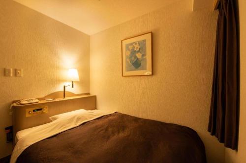 a hotel room with a bed and a picture on the wall at Albert Hotel in Akita