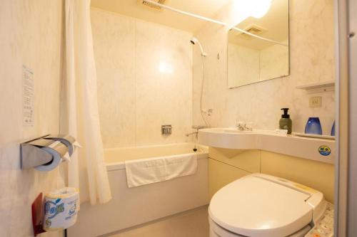 a bathroom with a toilet and a sink and a tub at Albert Hotel in Akita