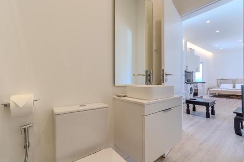 a white bathroom with a sink and a toilet at Downtown Studio Apartment G - 150m from the Beach in Albufeira