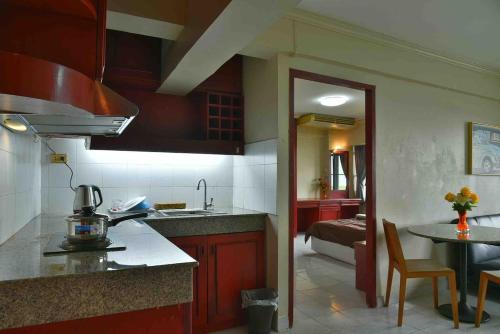 a kitchen with a sink and a table in a room at Petch Tower Ekamai Budget Serviced Apartments in Bangkok