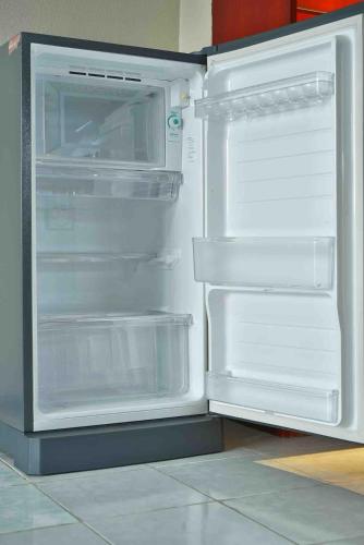 an empty refrigerator with its door open in a kitchen at Petch Tower Ekamai Budget Serviced Apartments in Bangkok