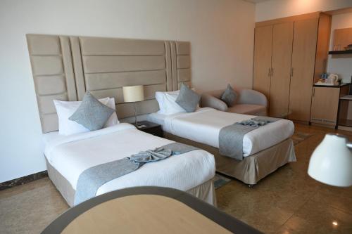a hotel room with two beds and a couch at Best Western Plus Mahboula in Kuwait