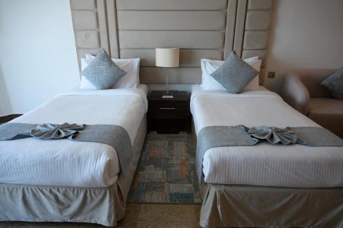 a hotel room with two beds and a couch at Best Western Plus Mahboula in Kuwait