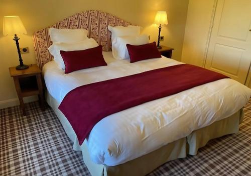 a bedroom with a large bed with red pillows at Château d'Ermenonville in Ermenonville