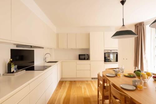 a kitchen with white cabinets and a wooden table at Family-Friendly Home for 10 in Prime Location in Copenhagen