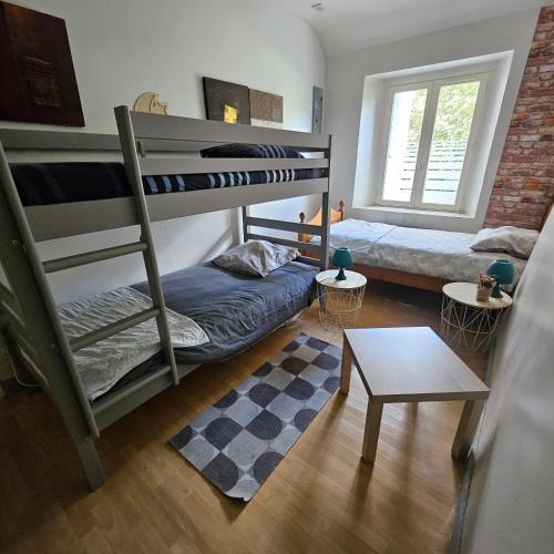une chambre avec deux lits superposés et une table dans l'établissement Gite 3 chambres chambres, calme et bien placé, à La Forest-Landerneau