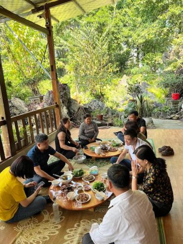 a group of people sitting around tables eating food at A Sính Homestay in Ha Giang